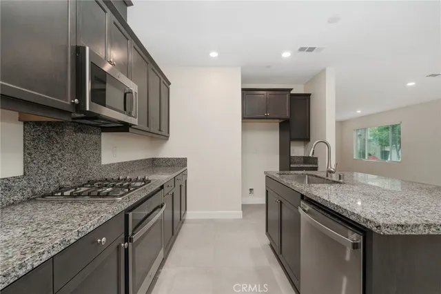 a kitchen with stainless steel appliances granite countertop a sink and a stove