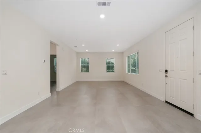 an empty room with windows and entrance