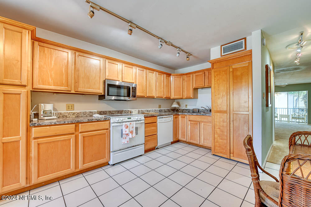 2321 Costa Verde Boulevard, Unit 201 Jacksonville Beach, FL 32250 - Photo 11 of 33 a kitchen with stainless steel appliances granite countertop a refrigerator and sink