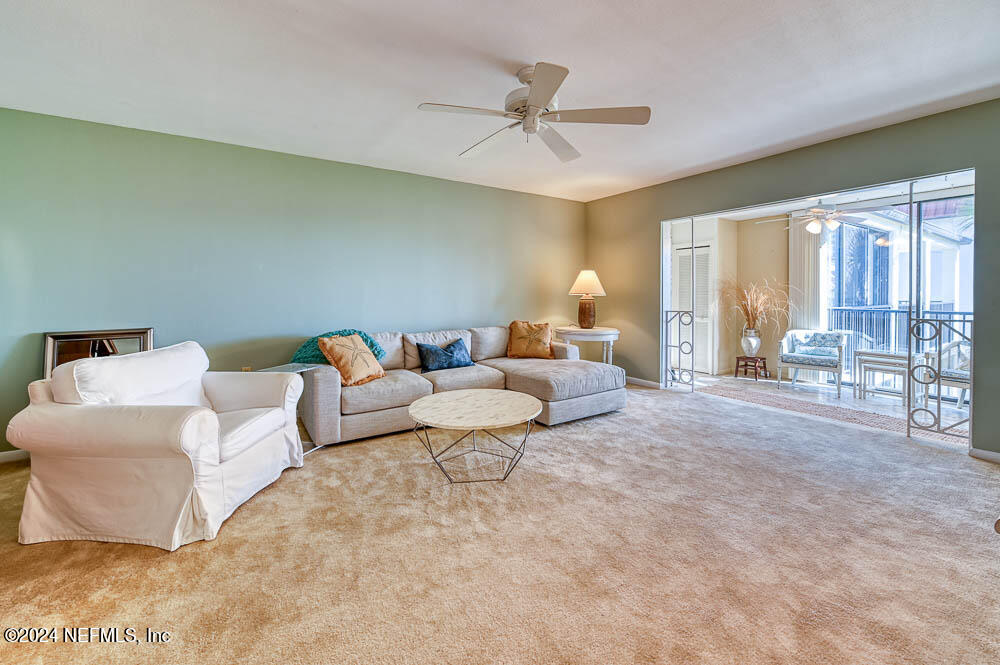 2321 Costa Verde Boulevard, Unit 201 Jacksonville Beach, FL 32250 - Photo 12 of 33 a living room with furniture and a ceiling fan
