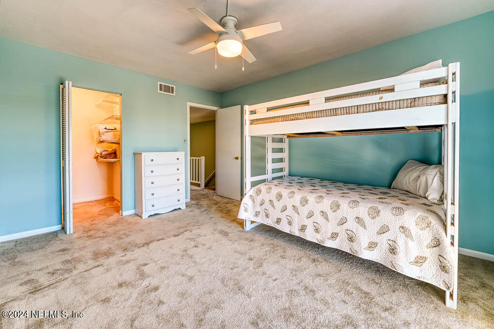 2321 Costa Verde Boulevard, Unit 201 Jacksonville Beach, FL 32250 - Photo 19 of 33 a bedroom with a bed and a chandelier