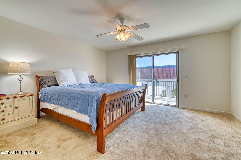 2321 Costa Verde Boulevard, Unit 201 Jacksonville Beach, FL 32250 - Photo 25 of 33 a bedroom with a bed and a chandelier