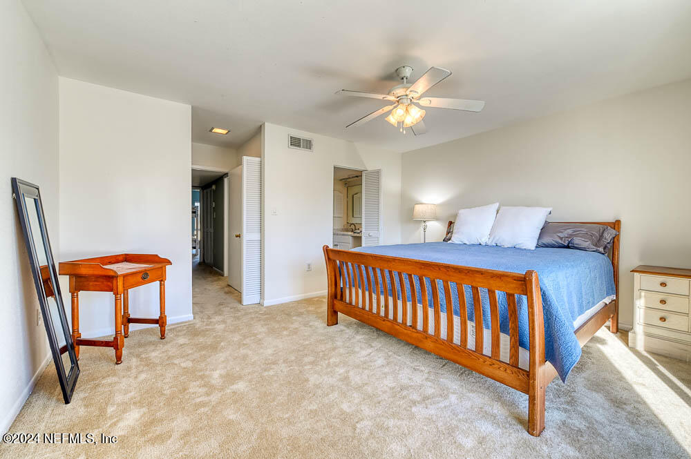 2321 Costa Verde Boulevard, Unit 201 Jacksonville Beach, FL 32250 - Photo 7 of 33 a bedroom with a bed and a chandelier
