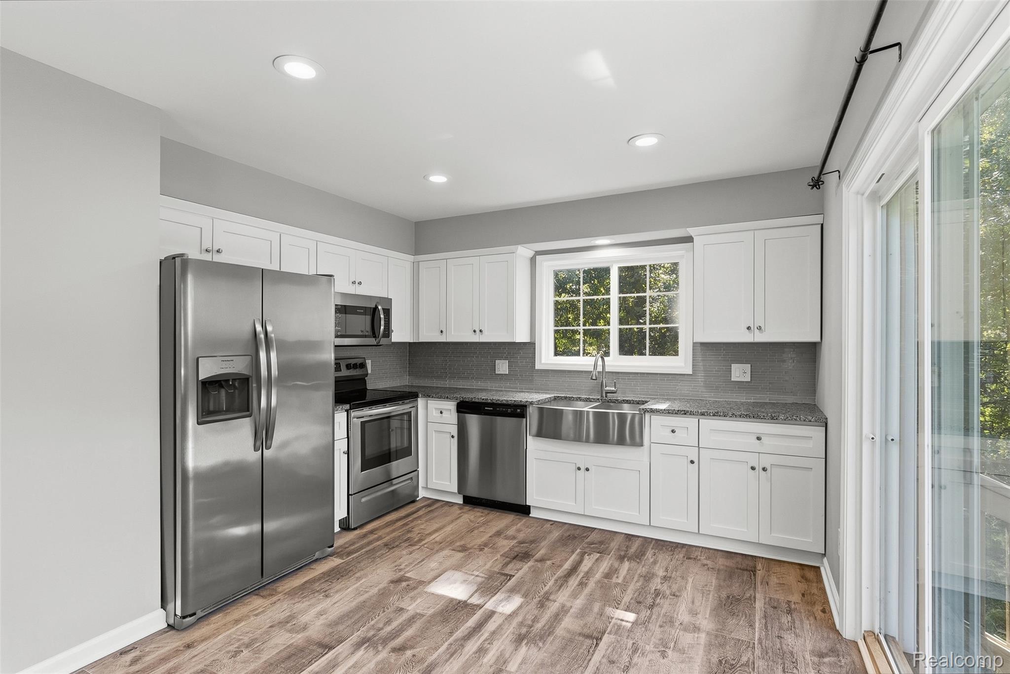 1750 Henbert Road West Bloomfield, MI 48324 - Photo 13 of 32 Kitchen featuring stainless steel appliances, wood-finish flooring, white cabinetry, recessed lighting, and a farmhouse sink