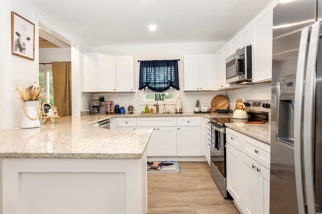 587 Oak Trace East Jasper, GA 30143 - Photo 20 of 47 a kitchen with stainless steel appliances granite countertop a sink dishwasher stove and refrigerator with wooden floor