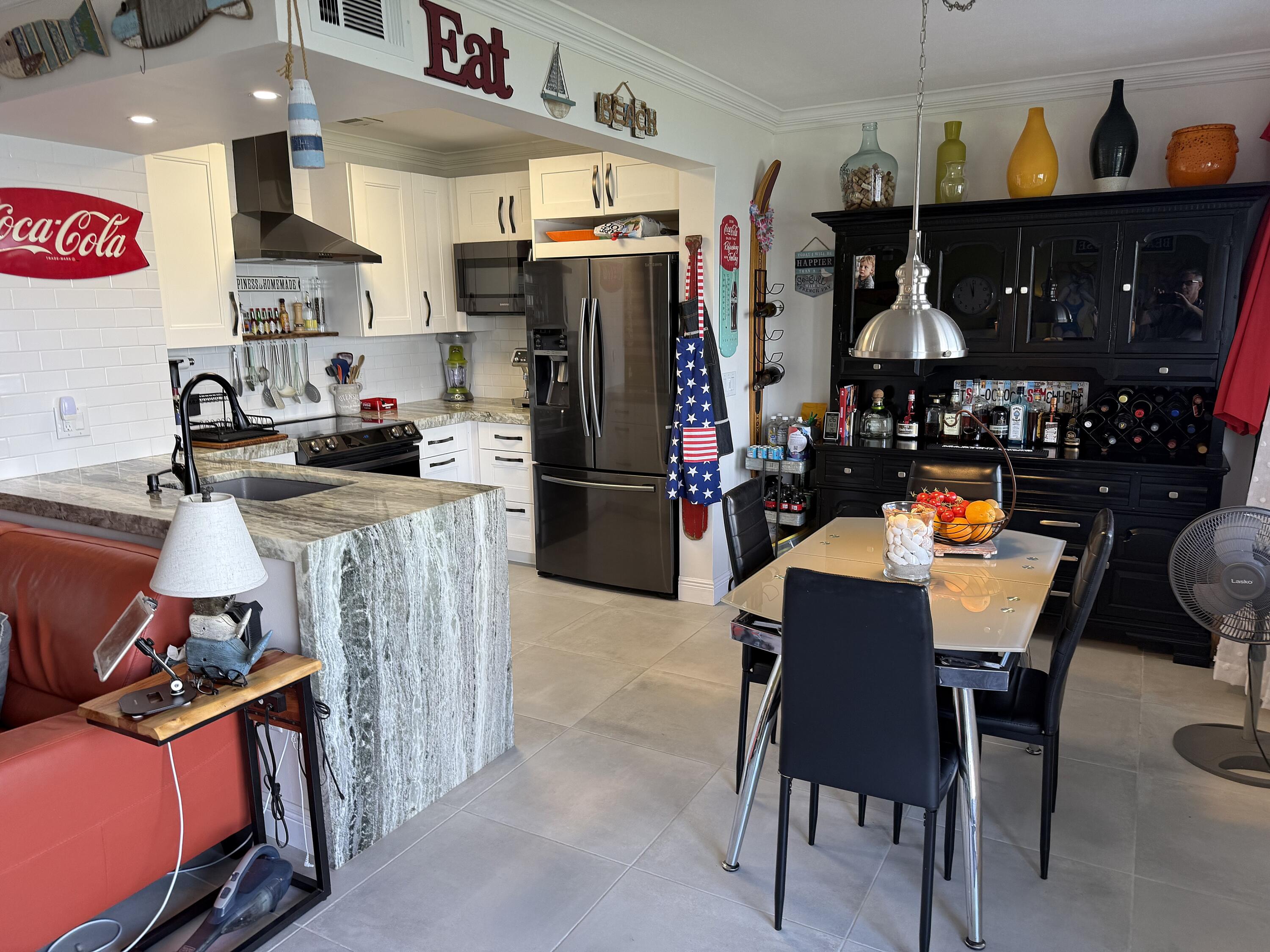 1201 South Riverside Drive, Unit 106 Pompano Beach, FL 33062 - Photo 3 of 28 a kitchen with stainless steel appliances a stove a refrigerator and a dining table
