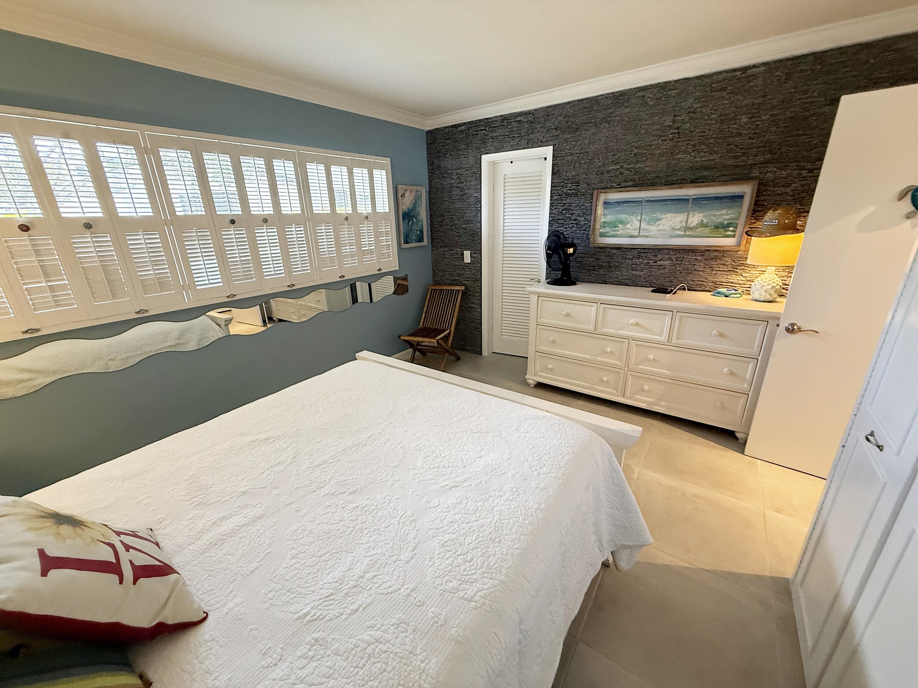 1201 South Riverside Drive, Unit 106 Pompano Beach, FL 33062 - Photo 6 of 28 a bedroom with a bed and a large window