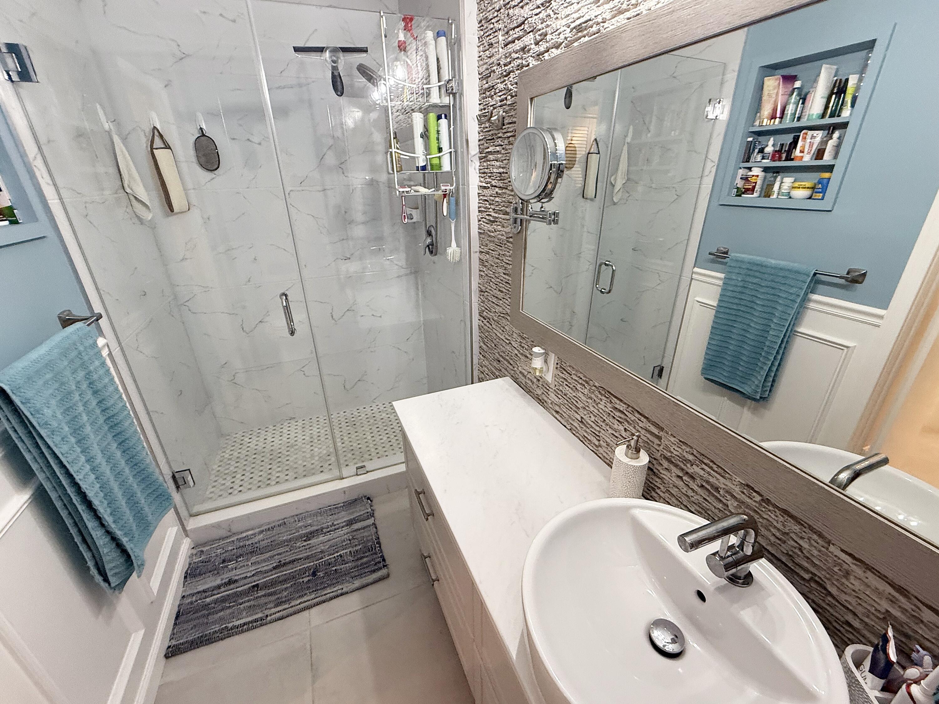 1201 South Riverside Drive, Unit 106 Pompano Beach, FL 33062 - Photo 8 of 28 a bathroom with a sink a mirror and a shower