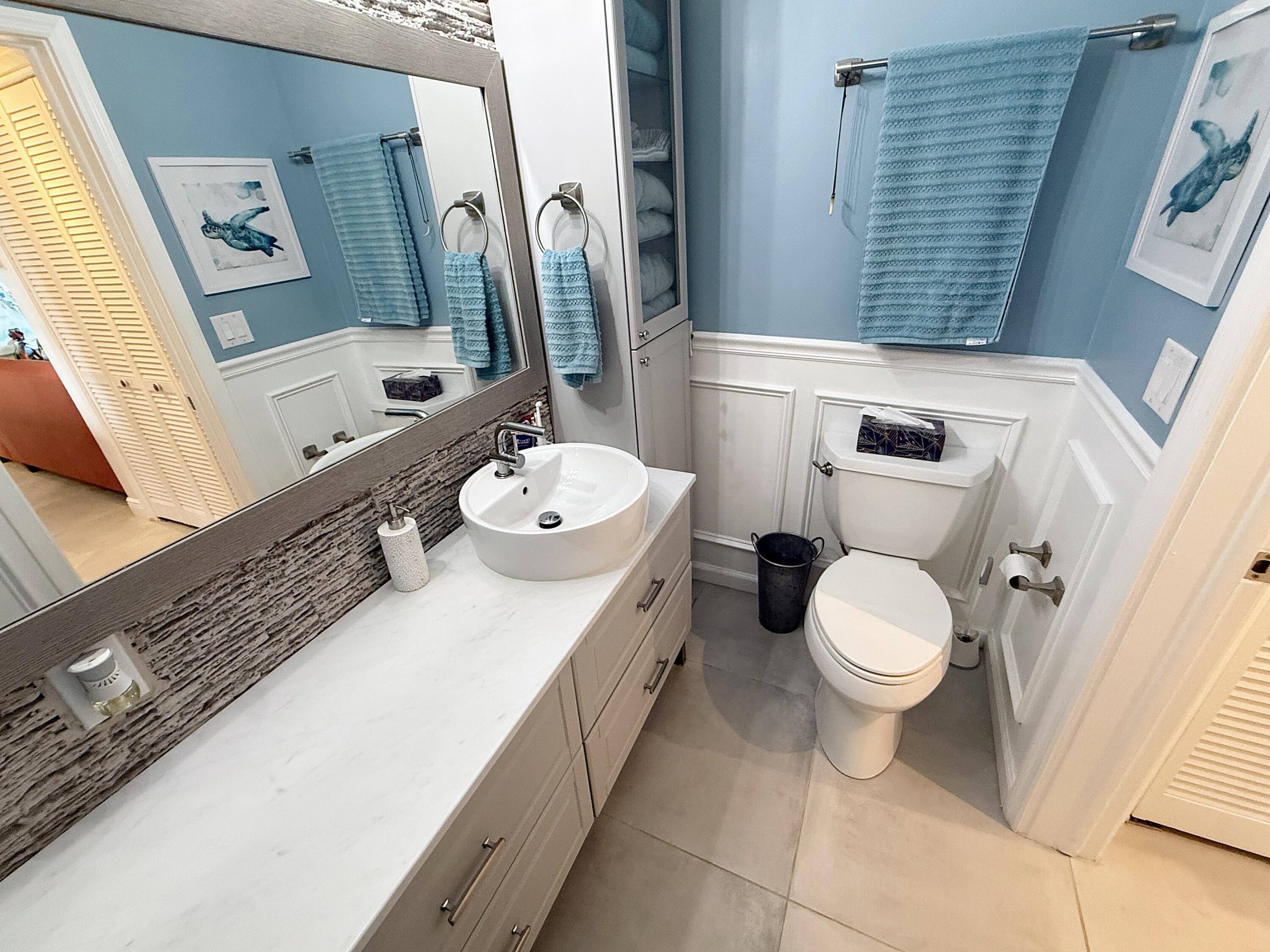 1201 South Riverside Drive, Unit 106 Pompano Beach, FL 33062 - Photo 9 of 28 a bathroom with a double vanity sink toilet and mirror
