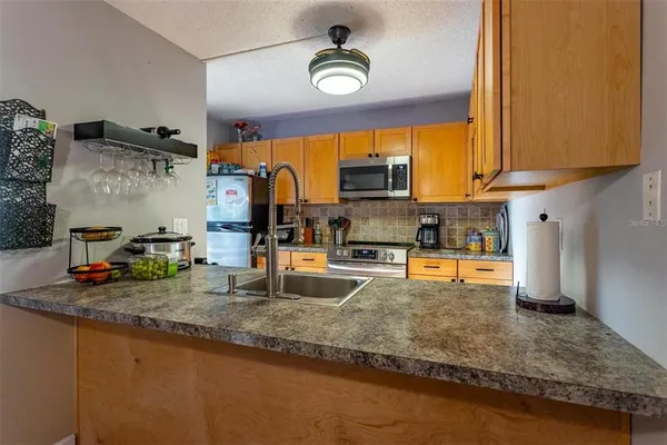 a kitchen with stainless steel appliances granite countertop a stove a sink and a microwave