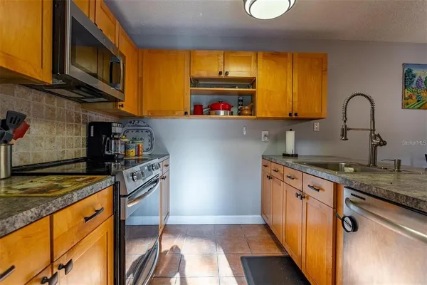 a kitchen with stainless steel appliances granite countertop a stove a sink and a microwave