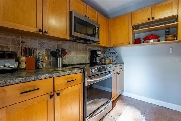 a kitchen with stainless steel appliances granite countertop a stove a microwave and a refrigerator