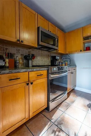 a kitchen with stainless steel appliances granite countertop a sink cabinets and wooden floor