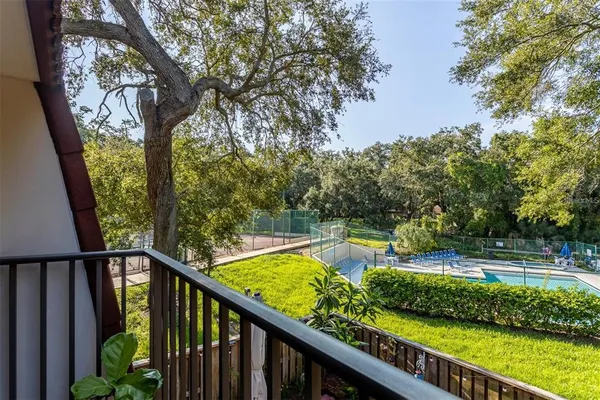 a view of a balcony with plants and trees