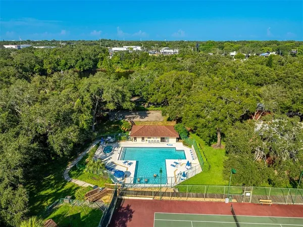 an aerial view of residential houses with outdoor space and trees