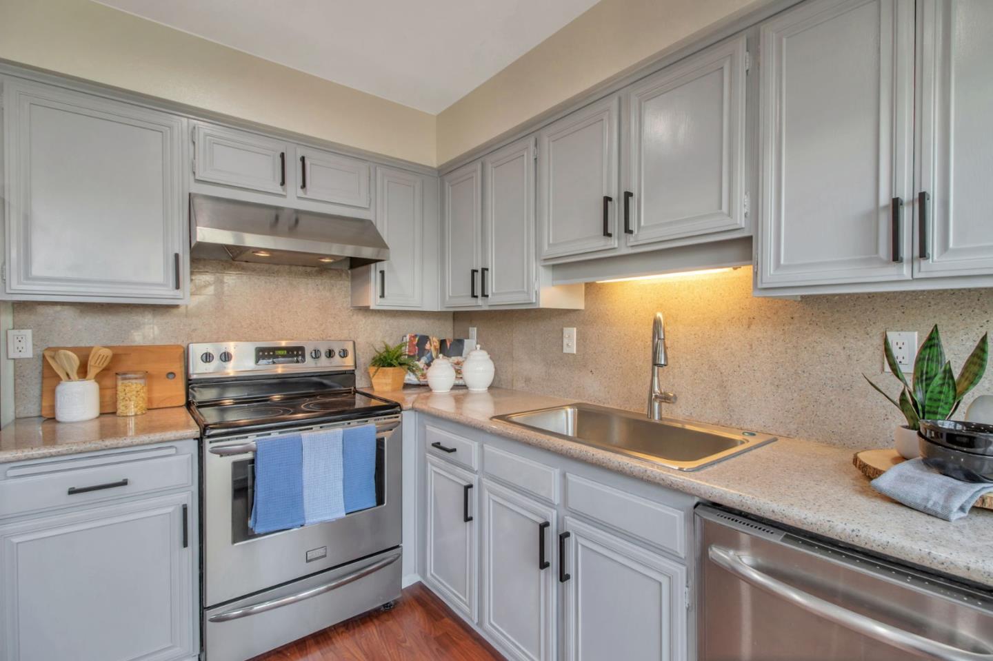 4793 Corte De Cervato San Jose, CA 95136 - Photo 22 of 45 a kitchen with granite countertop white cabinets and a stove