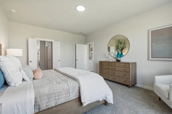 a bedroom with a bed and large windows