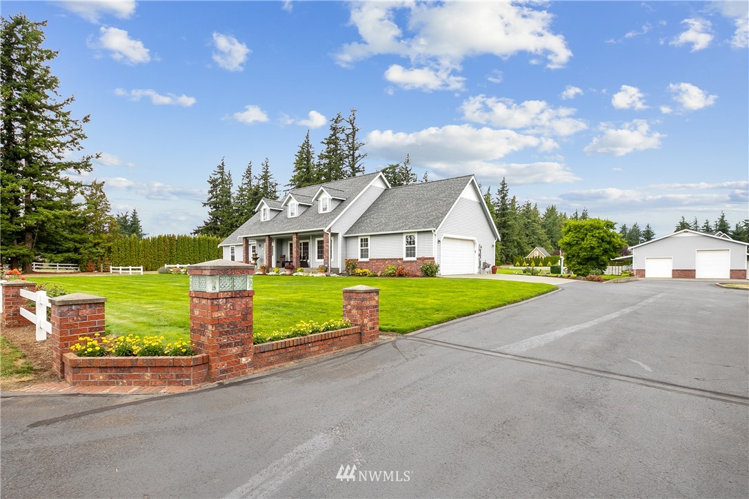 a view of a house with a big yard plants and large trees