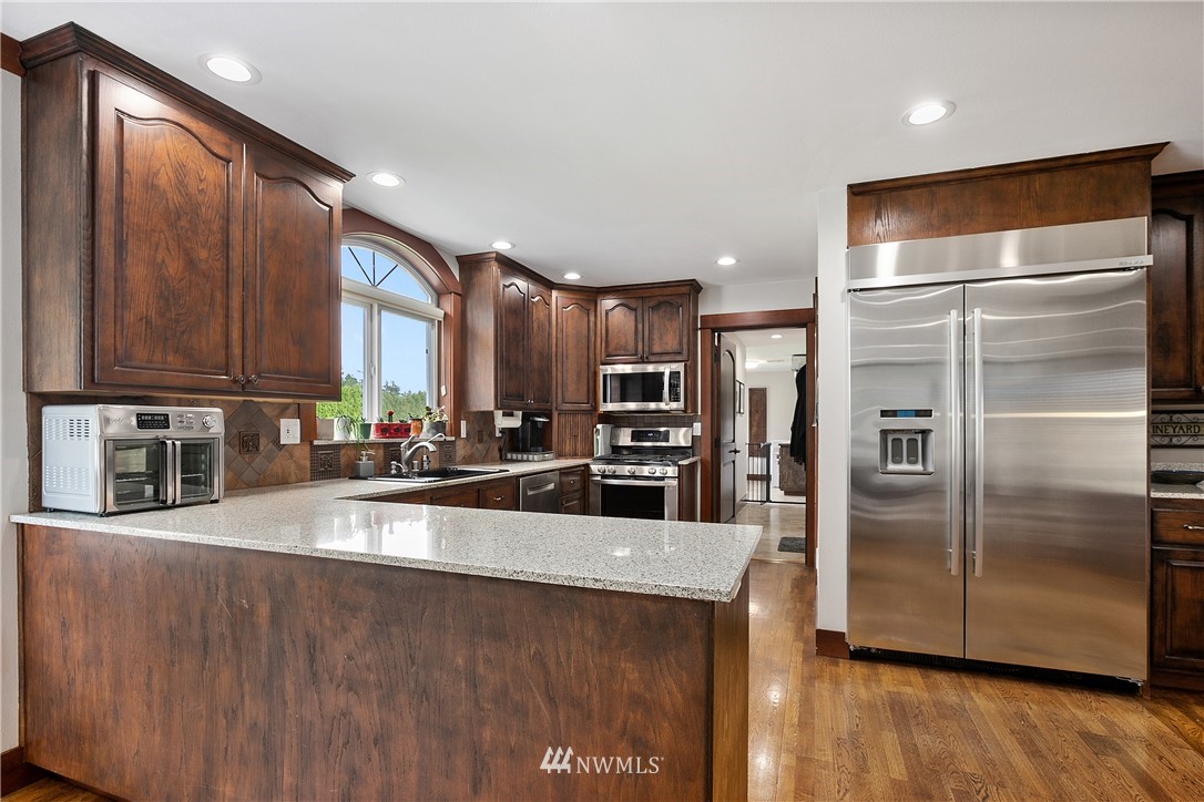 810 East Wiser Lake Road Lynden, WA 98264 - Photo 12 of 40 a kitchen with stainless steel appliances granite countertop a refrigerator a sink a stove and a wooden cabinets