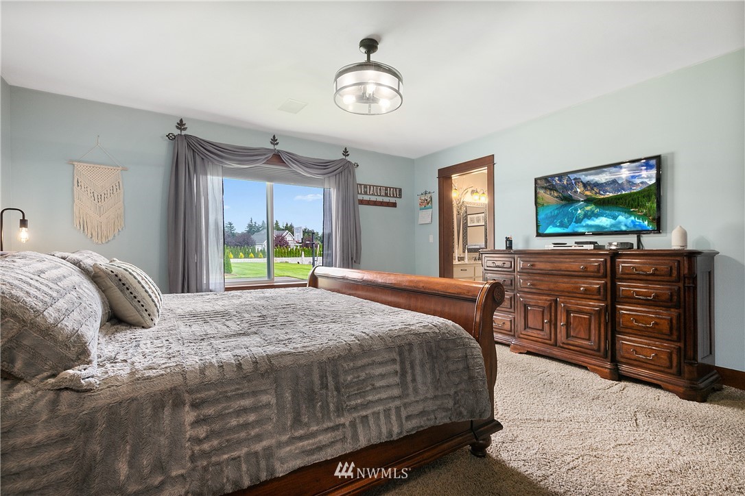 810 East Wiser Lake Road Lynden, WA 98264 - Photo 15 of 40 a bedroom with a bed and a flat tv screen on dresser