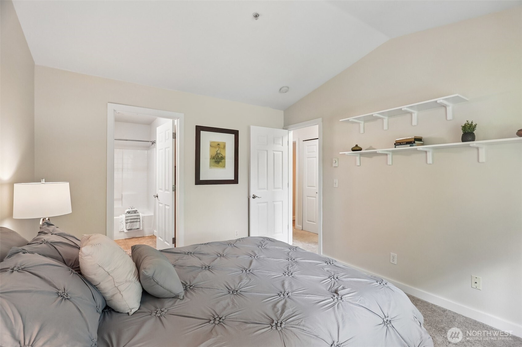18930 Bothell Everett Highway, Unit E301 Bothell, WA 98012 - Photo 13 of 28 a bedroom with a bed and a lamp