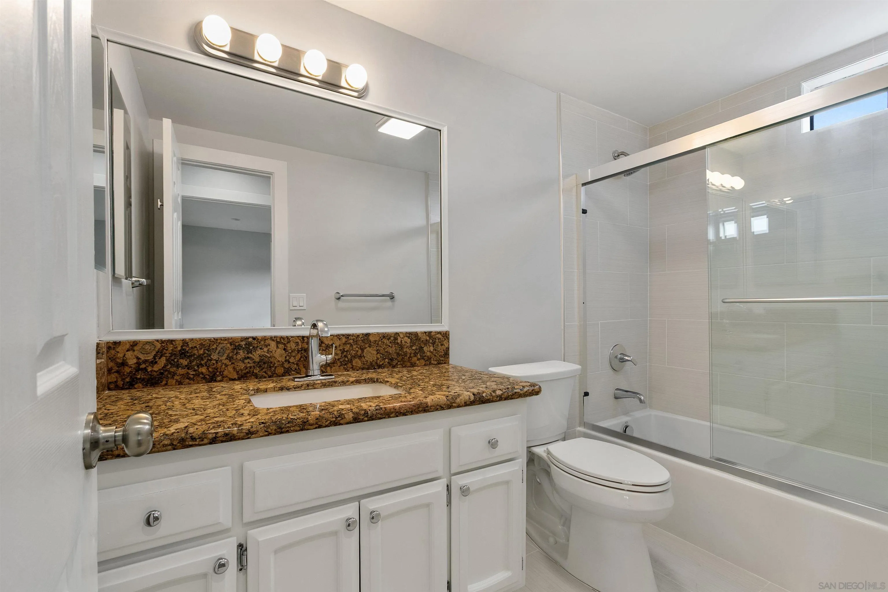 520 Pearl Street, Unit 2 La Jolla, CA 92037 - Photo 11 of 27 a bathroom with a granite countertop sink a toilet and shower