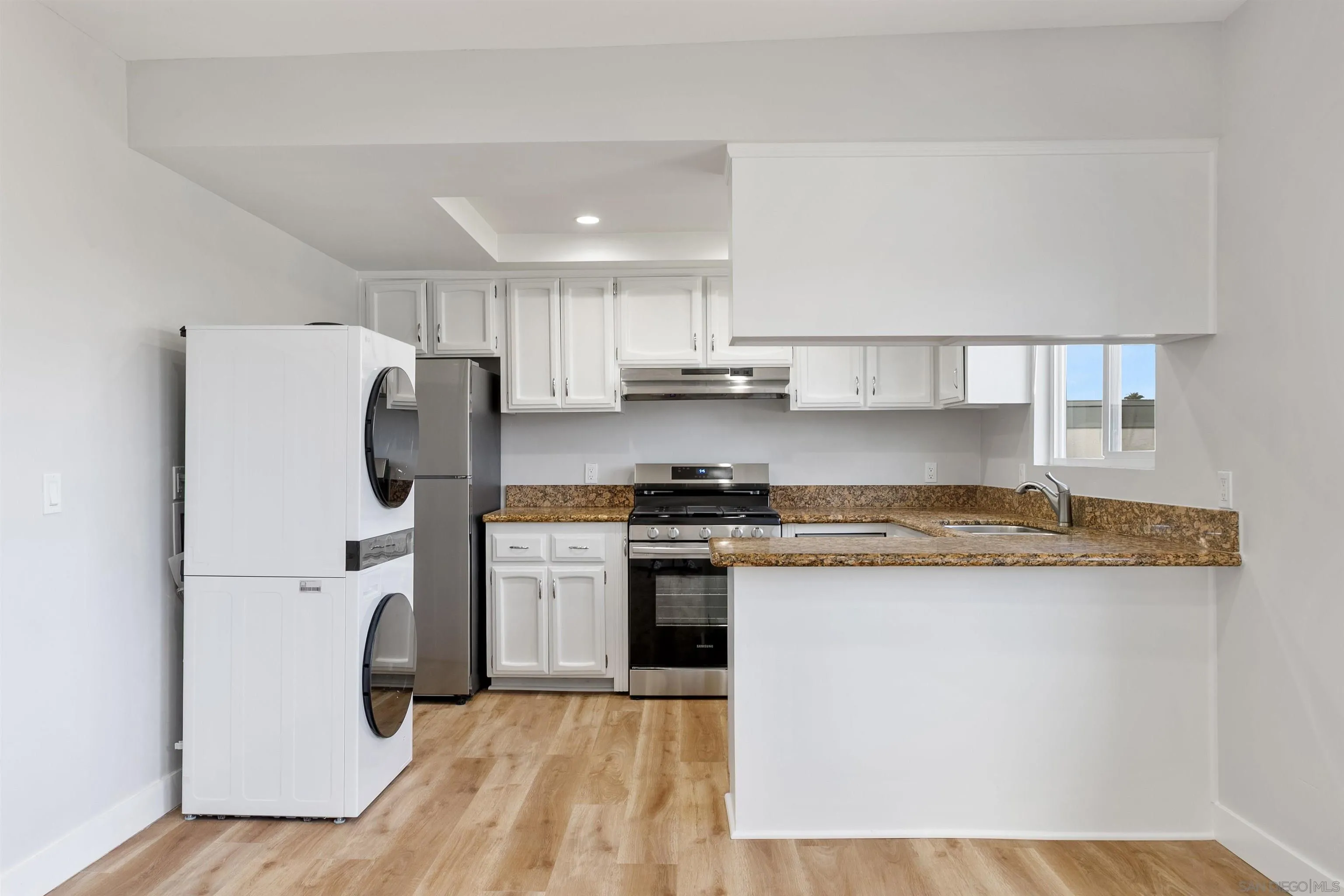 520 Pearl Street, Unit 2 La Jolla, CA 92037 - Photo 6 of 27 a kitchen with stainless steel appliances granite countertop a refrigerator a stove and a sink