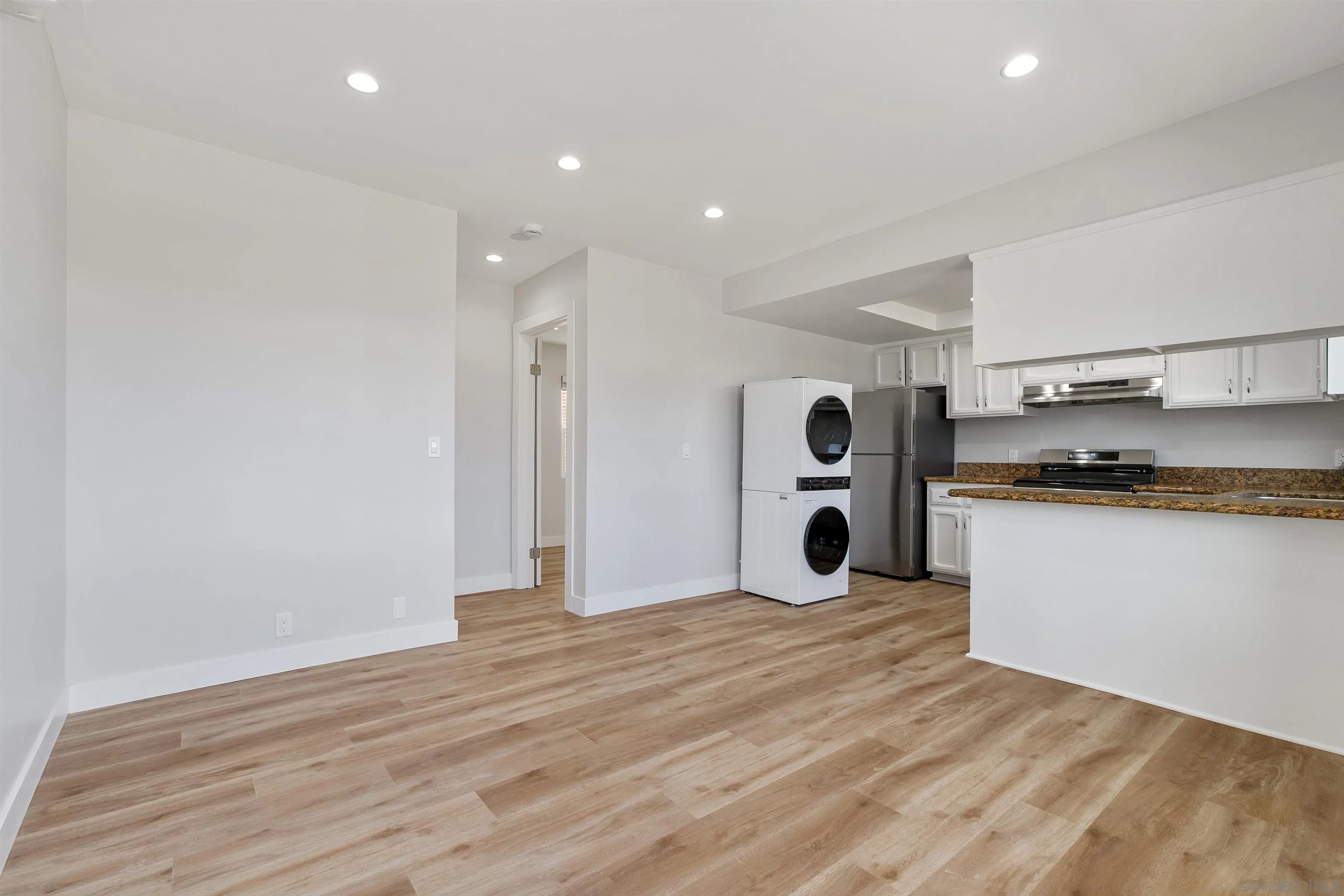 520 Pearl Street, Unit 2 La Jolla, CA 92037 - Photo 7 of 27 a view of kitchen and empty room with wooden floor