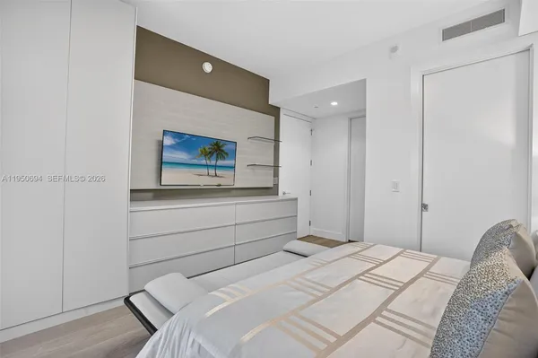 a bedroom with a bed and a flat screen tv