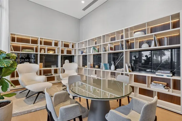 a dining room with furniture a floor to ceiling window and wooden floor