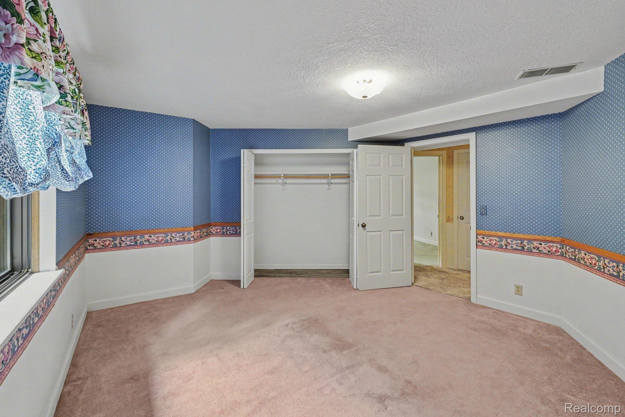 4425 North Henderson Road Davison, MI 48423 - Photo 26 of 43 Carpeted room featuring a window, built-in closet, and overhead lighting