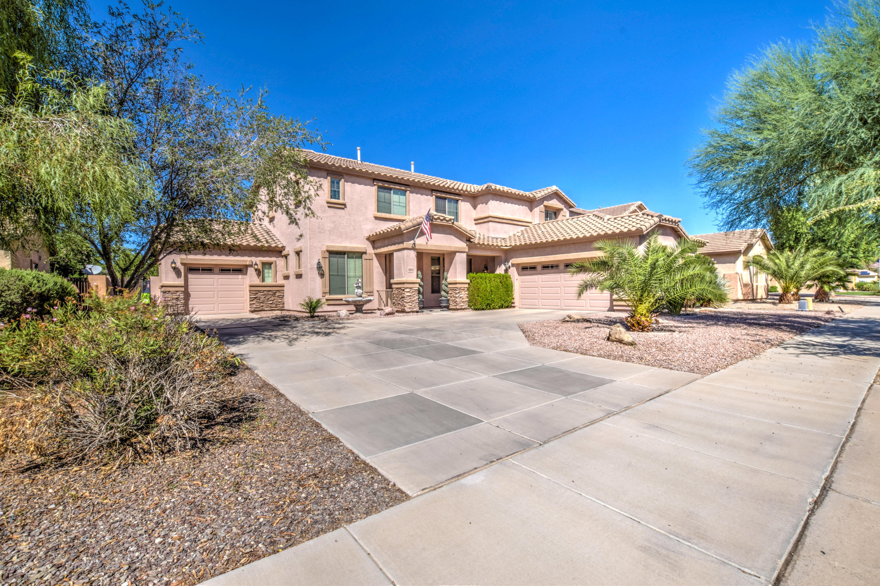 a view of a white building among the street with palm trees