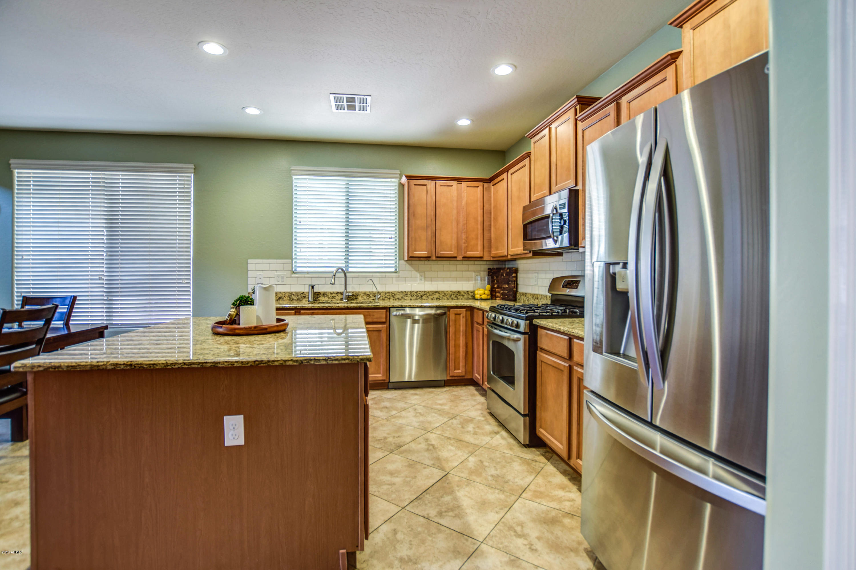 19702 East Thornton Road Queen Creek, AZ 85142 - Photo 18 of 79 a kitchen with stainless steel appliances granite countertop a refrigerator a sink a stove and island