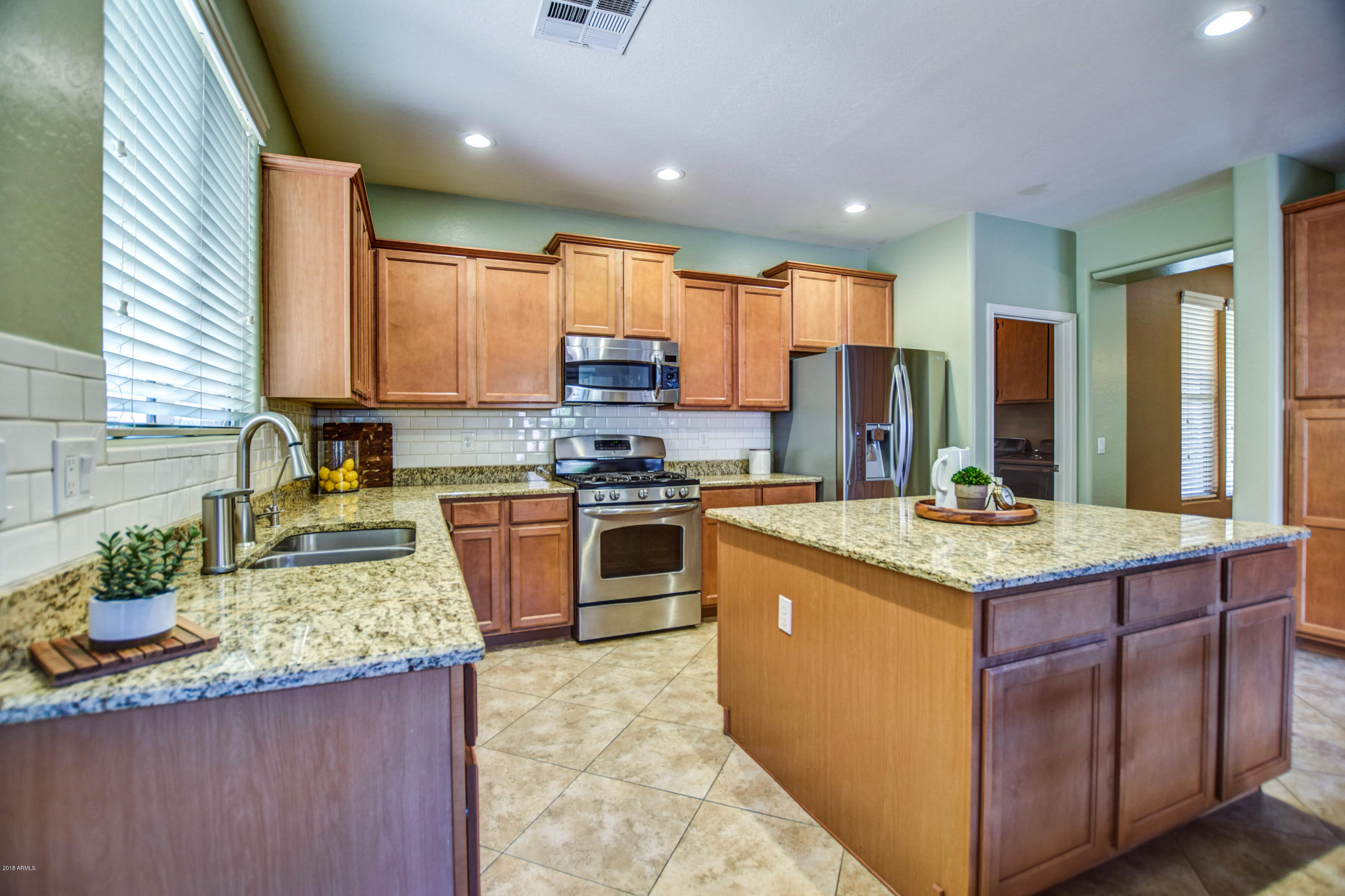 19702 East Thornton Road Queen Creek, AZ 85142 - Photo 3 of 79 a kitchen with stainless steel appliances granite countertop a stove a sink and a refrigerator