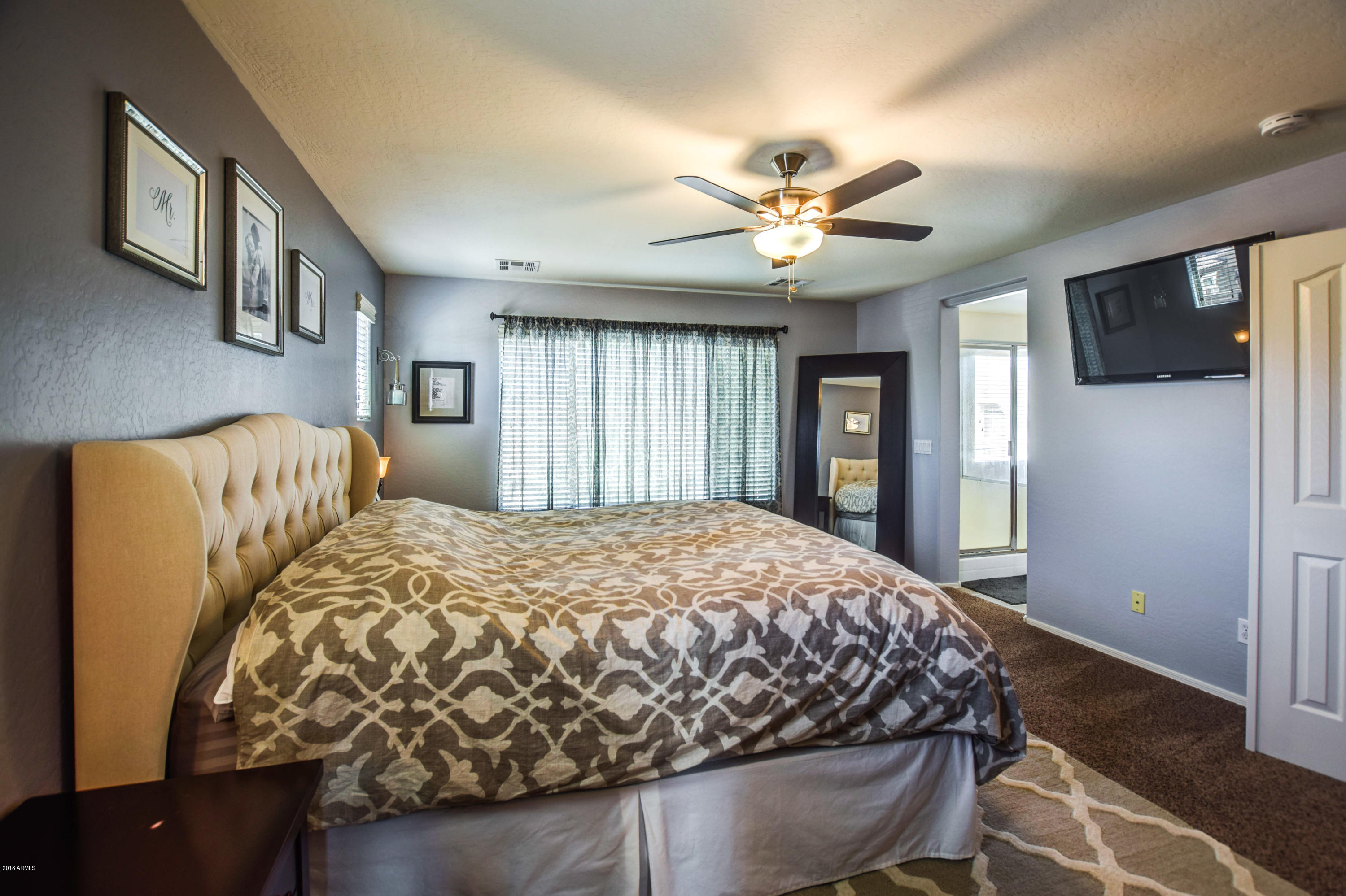 19702 East Thornton Road Queen Creek, AZ 85142 - Photo 34 of 79 a bedroom with a large bed and a chandelier