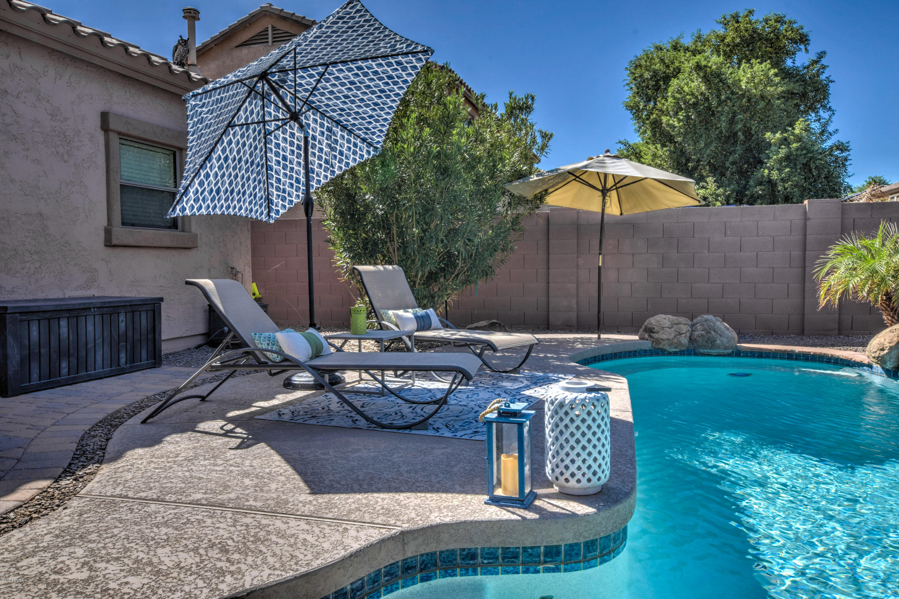 19702 East Thornton Road Queen Creek, AZ 85142 - Photo 68 of 79 a view of a backyard with table and chairs under an umbrella