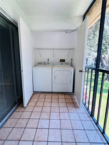 a utility room with washing machine and cabinets