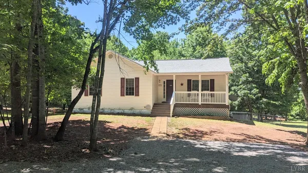 a front view of a house with a yard and tree