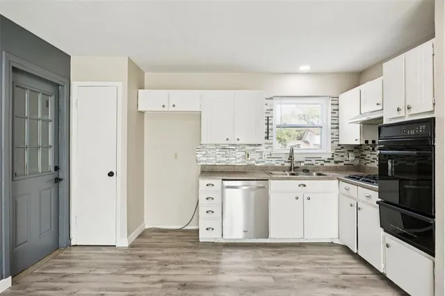 a kitchen with granite countertop a refrigerator stove top oven and sink