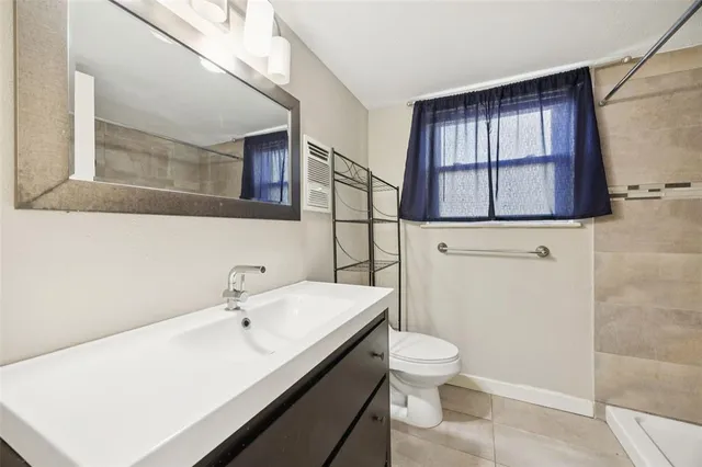 a bathroom with a sink a toilet and mirror