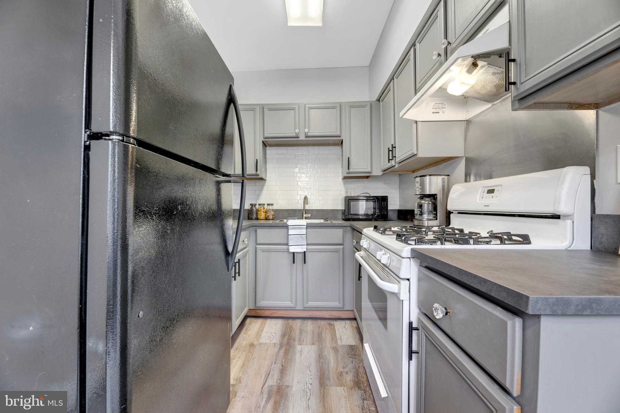 1436 W Street Northwest, Unit 405 Washington, DC 20009 - Photo 7 of 13 a kitchen with a sink stove and refrigerator
