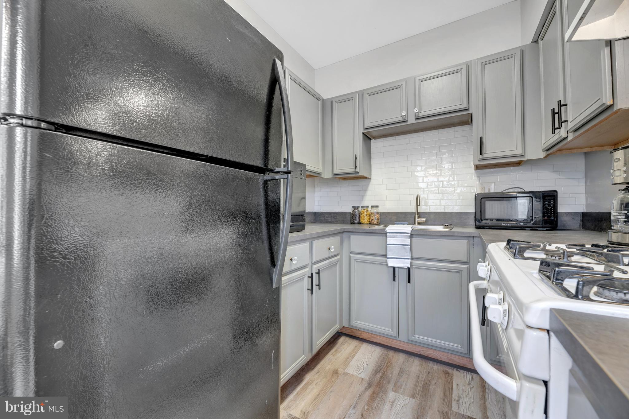 1436 W Street Northwest, Unit 405 Washington, DC 20009 - Photo 8 of 13 a kitchen with stainless steel appliances refrigerator stove microwave and cabinets