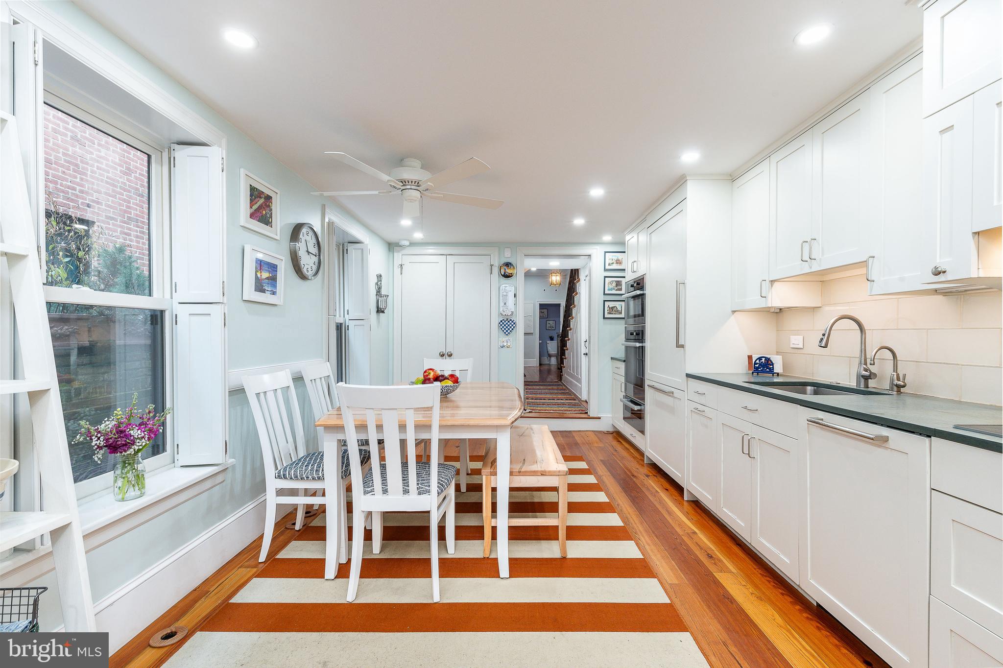517 Pine Street Philadelphia, PA 19106 - Photo 15 of 63 a kitchen with stainless steel appliances granite countertop a dining table chairs and white cabinets