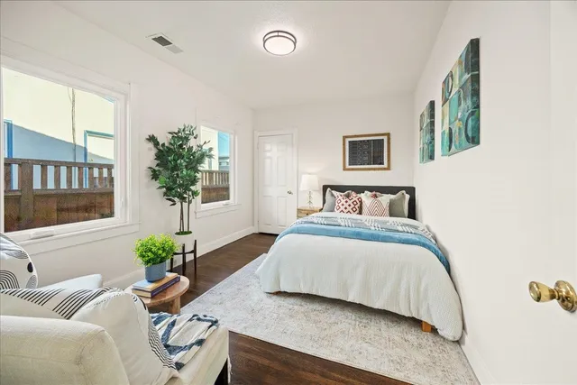 a bedroom with a bed mirror and a window