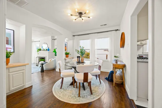 a living room with furniture a dining table and a chandelier