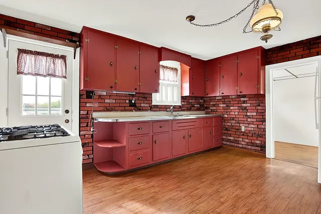a kitchen with sink a microwave and cabinets