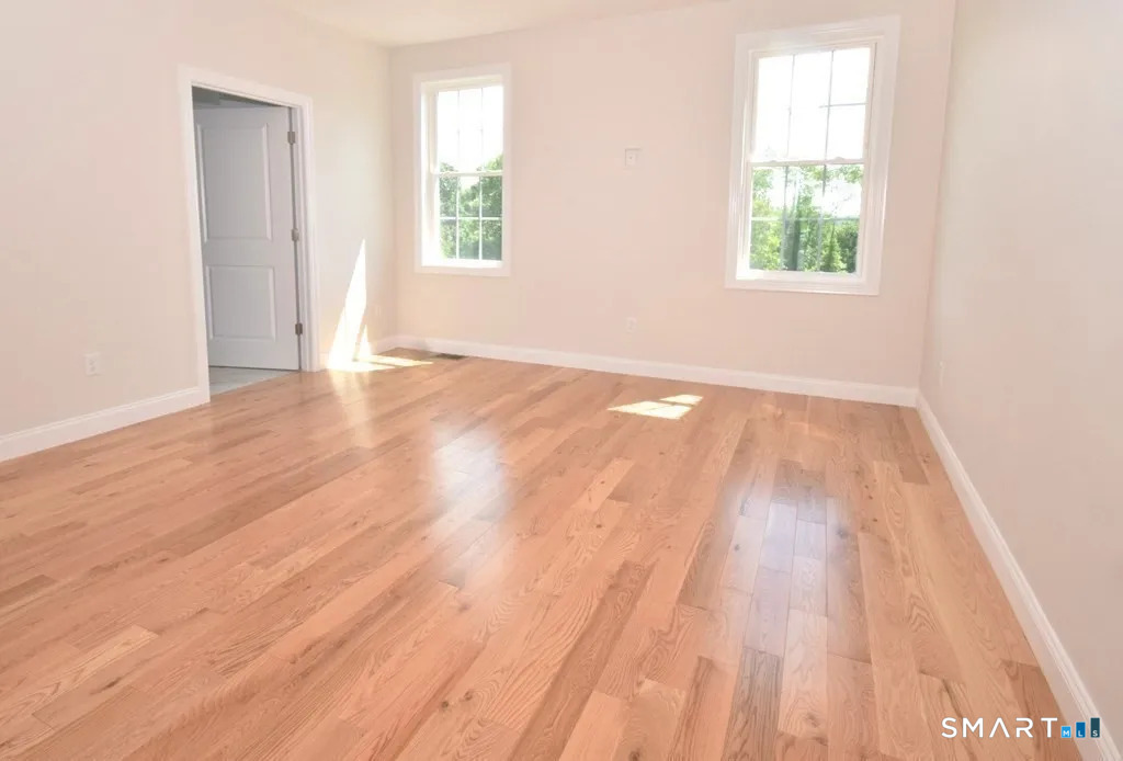 80 Aldrich Road Putnam, CT 06260 - Photo 7 of 23 an empty room with wooden floor and windows
