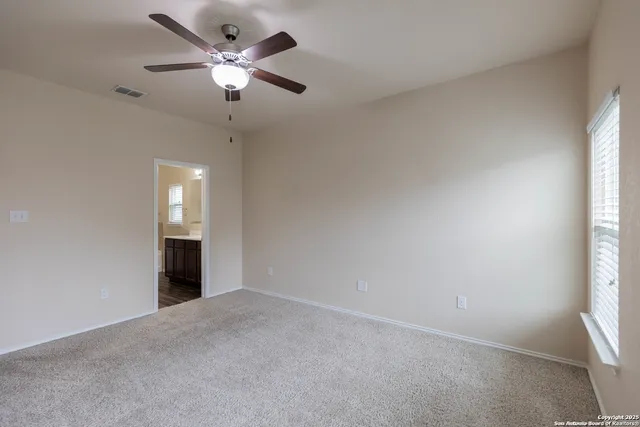 an empty room with fan and windows