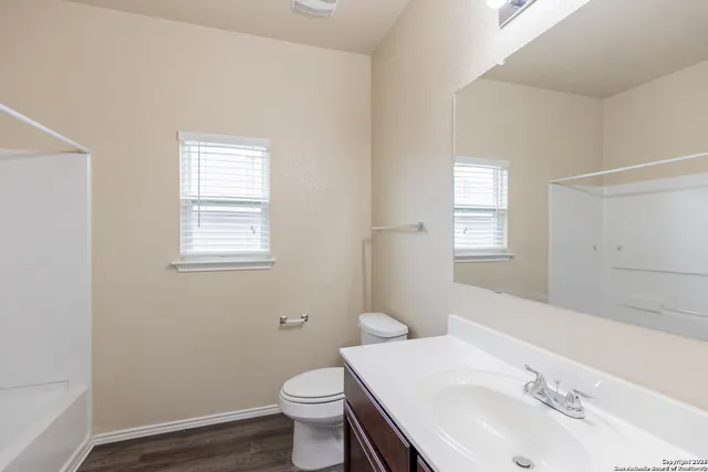 a bathroom with a sink toilet and window