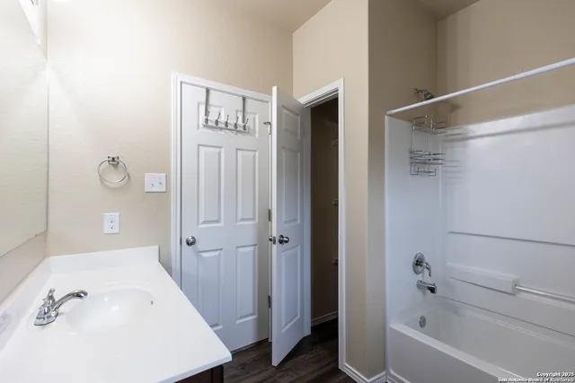 a bathroom with a tub shower and sink